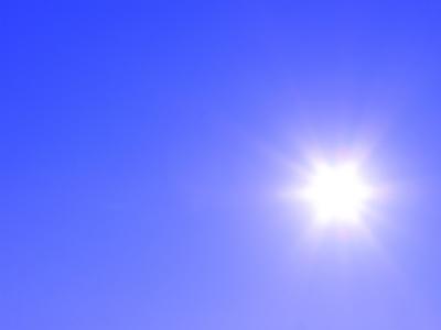 The image shows a bright sun shining in a clear blue sky, with visible sun rays radiating outward.